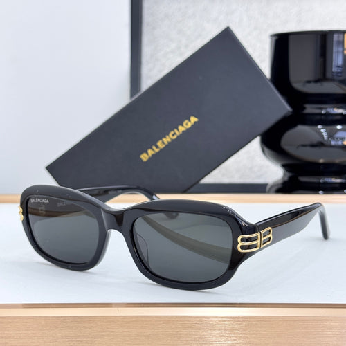 Balenciaga sunglasses with black frame, dark lenses, and gold logo at temple