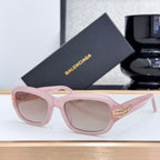 Balenciaga sunglasses with light pink frame, pink-tinted lenses, and gold temple logo