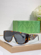 Gucci sunglasses with tortoiseshell oversized frames and dark tinted lenses, metal logo