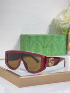 Gucci sunglasses with burgundy oversized frames and amber tinted lenses, metal logo detail