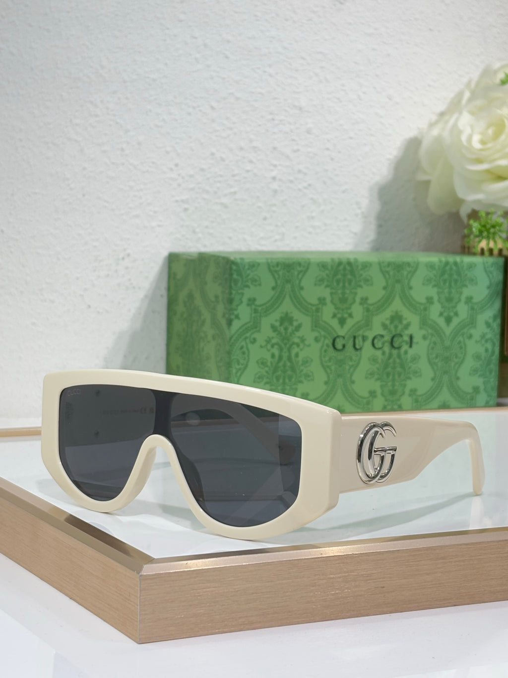 Gucci sunglasses with white oversized frames and dark tinted lenses, metal logo detail