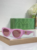 Sunglasses with purple frames, brown-tinted lenses, and a gold GG emblem on the temple.