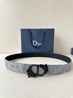 Belt with silver-gray textured strap and black ornate buckle