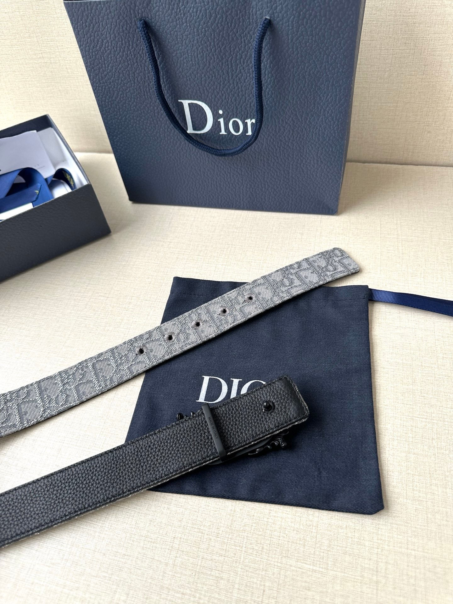 Belt with silver-gray strap and black buckle, laid flat
