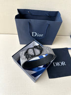 Two-tone belt with silver-gray patterned strap and black reverse, flat lay
