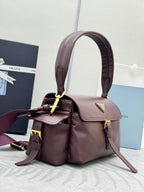 Burgundy Prada handbag with top handle, front flap and gold hardware with strap