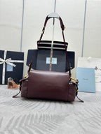 Burgundy Prada satchel bag with front flap, dual straps, and gold hardware