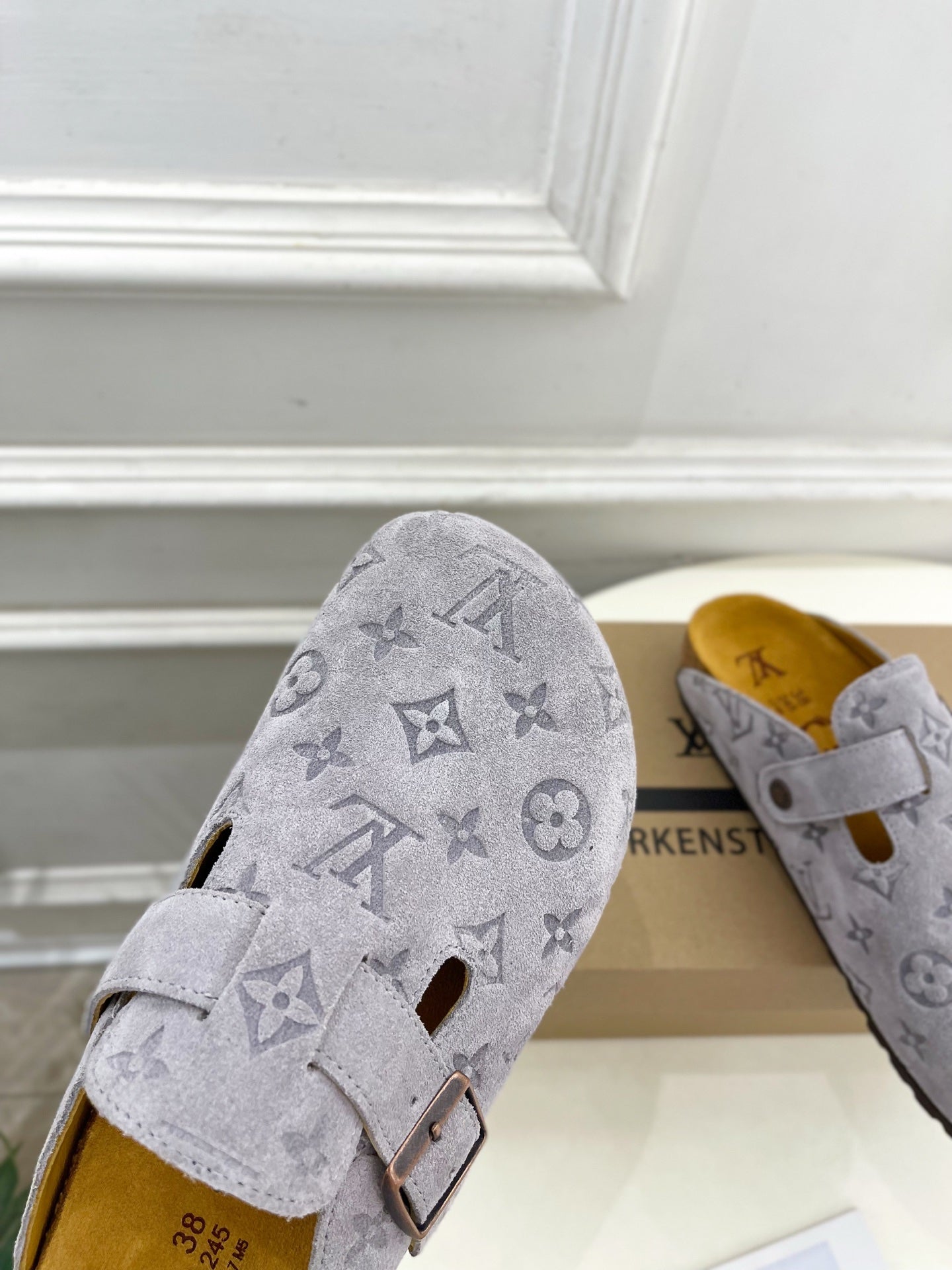 Monogram slide sandal in light gray with adjustable strap and metal buckle, close-up