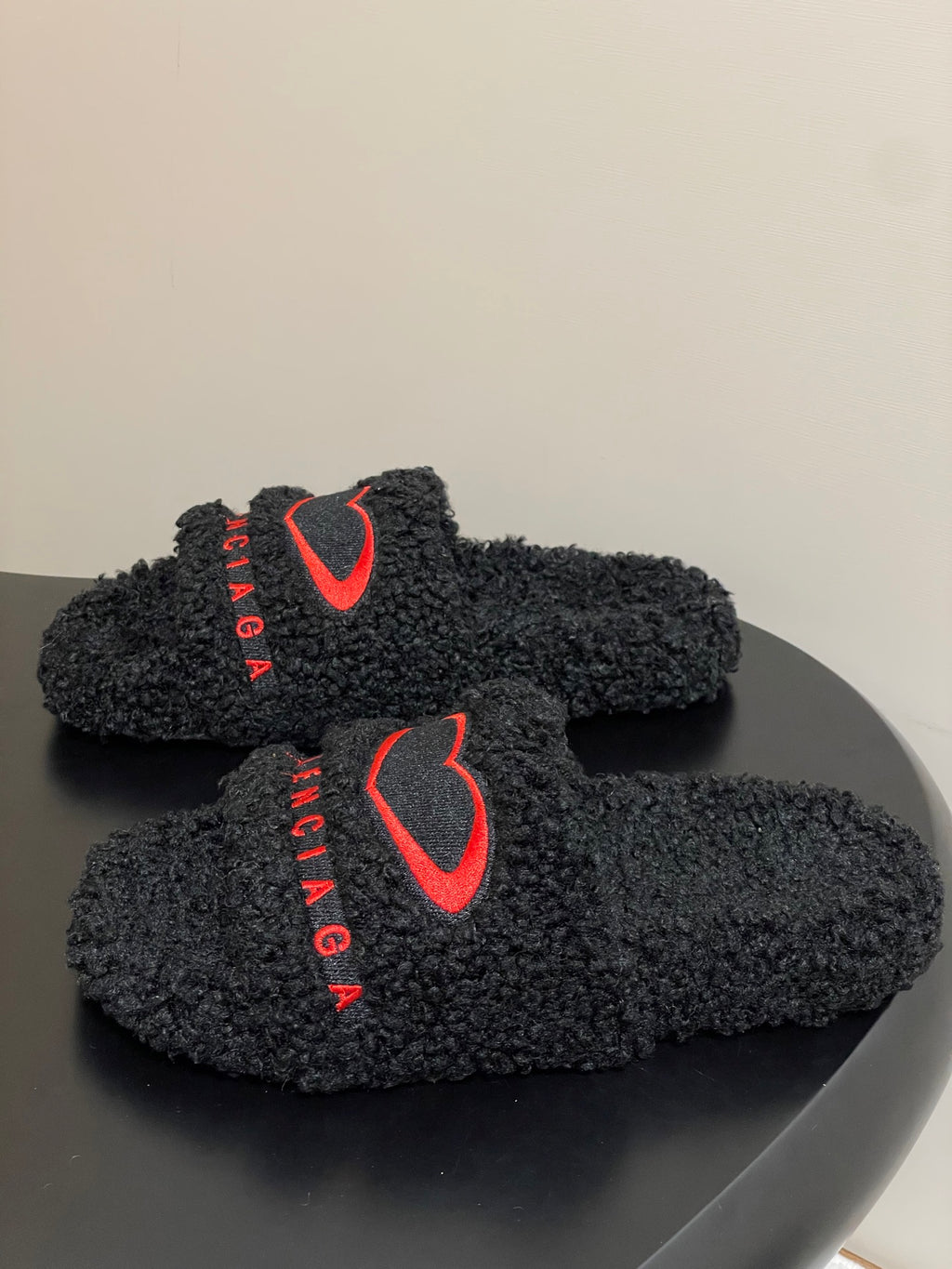 Black teddy-fleece slide sandals with red heart logo on front strap, BALENCIAGA text