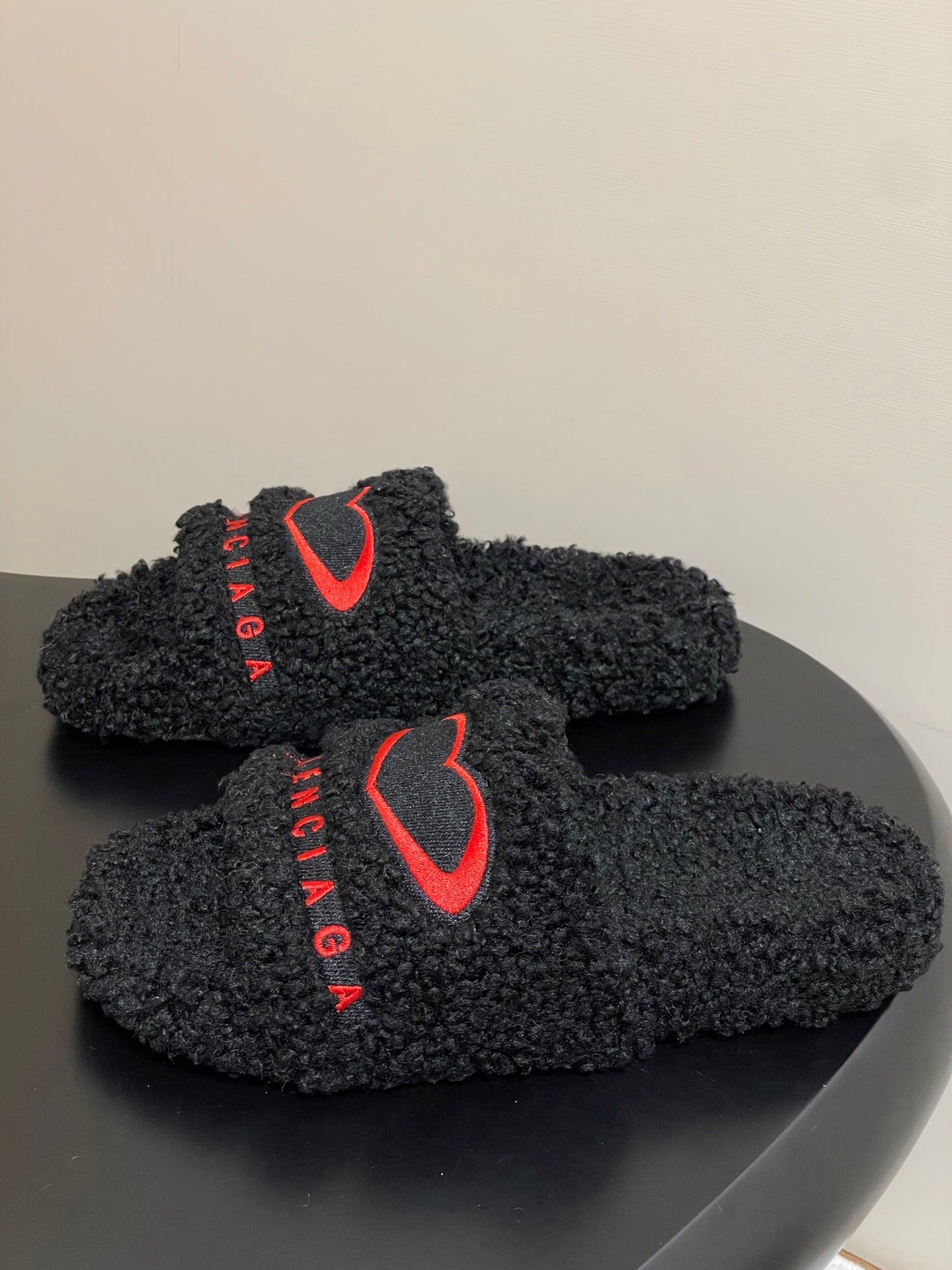 Black teddy-fleece slide sandals with red heart logo on front strap, BALENCIAGA text