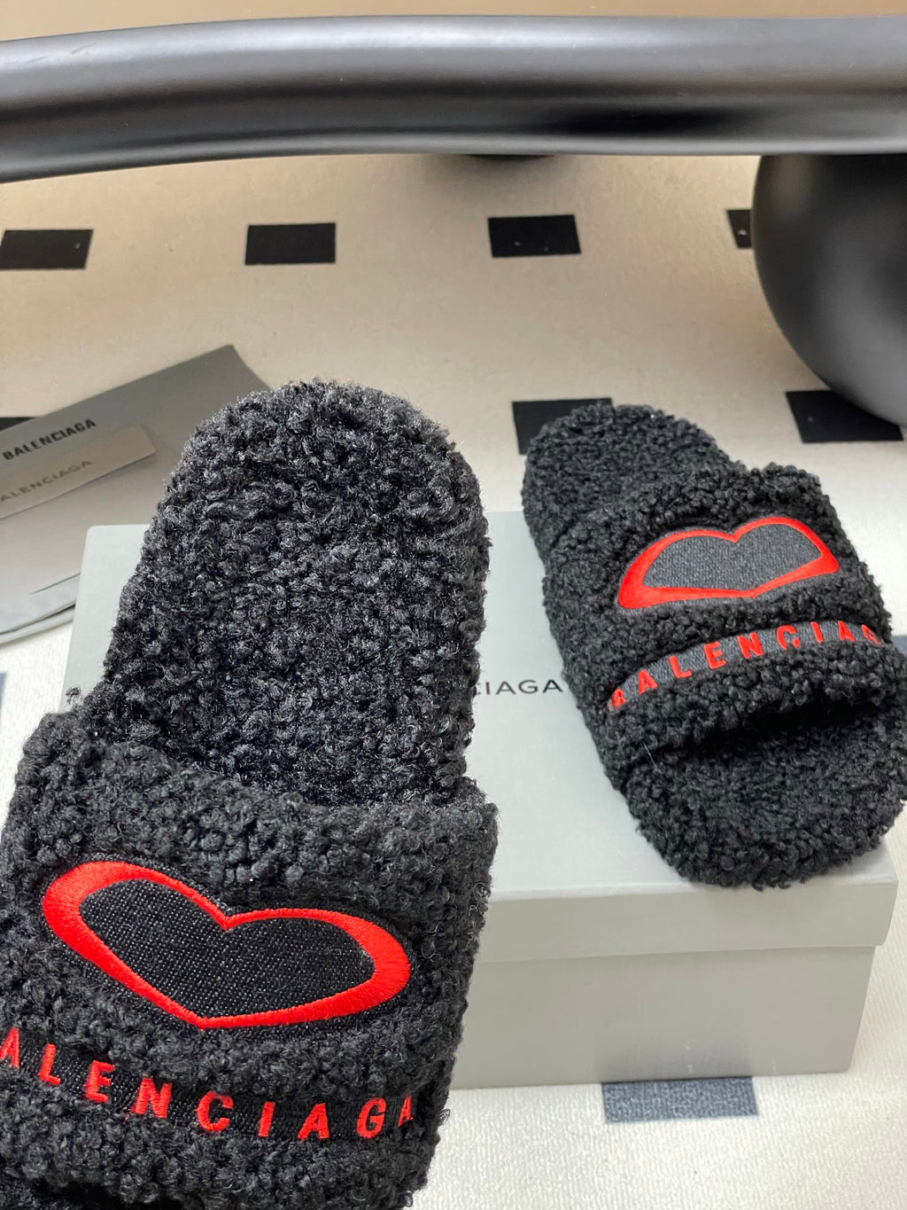 Black teddy-fleece slide sandals with large red heart logo and BALENCIAGA lettering