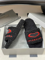 Black teddy-fleece slide sandals with red heart logo and red BALENCIAGA lettering