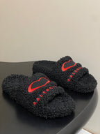 Black teddy-fleece slide sandals with red heart logo and red BALENCIAGA lettering