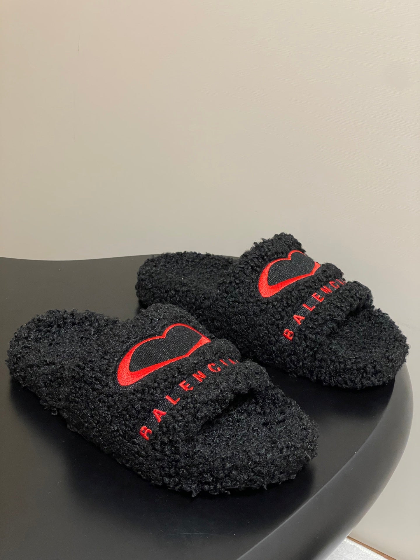 Black teddy-fleece slide sandals with red heart logo and red BALENCIAGA lettering