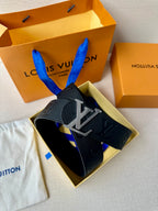 Louis Vuitton belt shown in gift box: dark embossed leather with gold-tone buckle