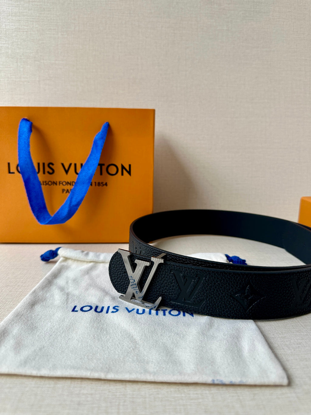 Louis Vuitton belt on dust bag: dark embossed leather with gold-tone LV buckle