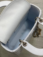 Dior handbag interior view with light blue lining and metal clasp hardware