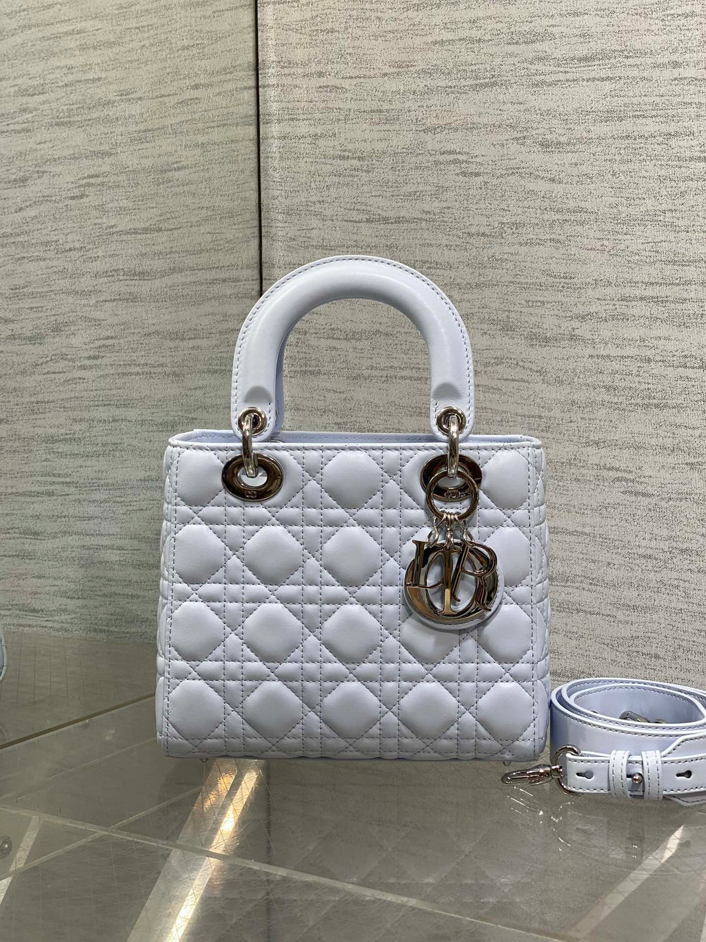 Quilted light blue Dior handbag with gold hardware and detachable shoulder strap
