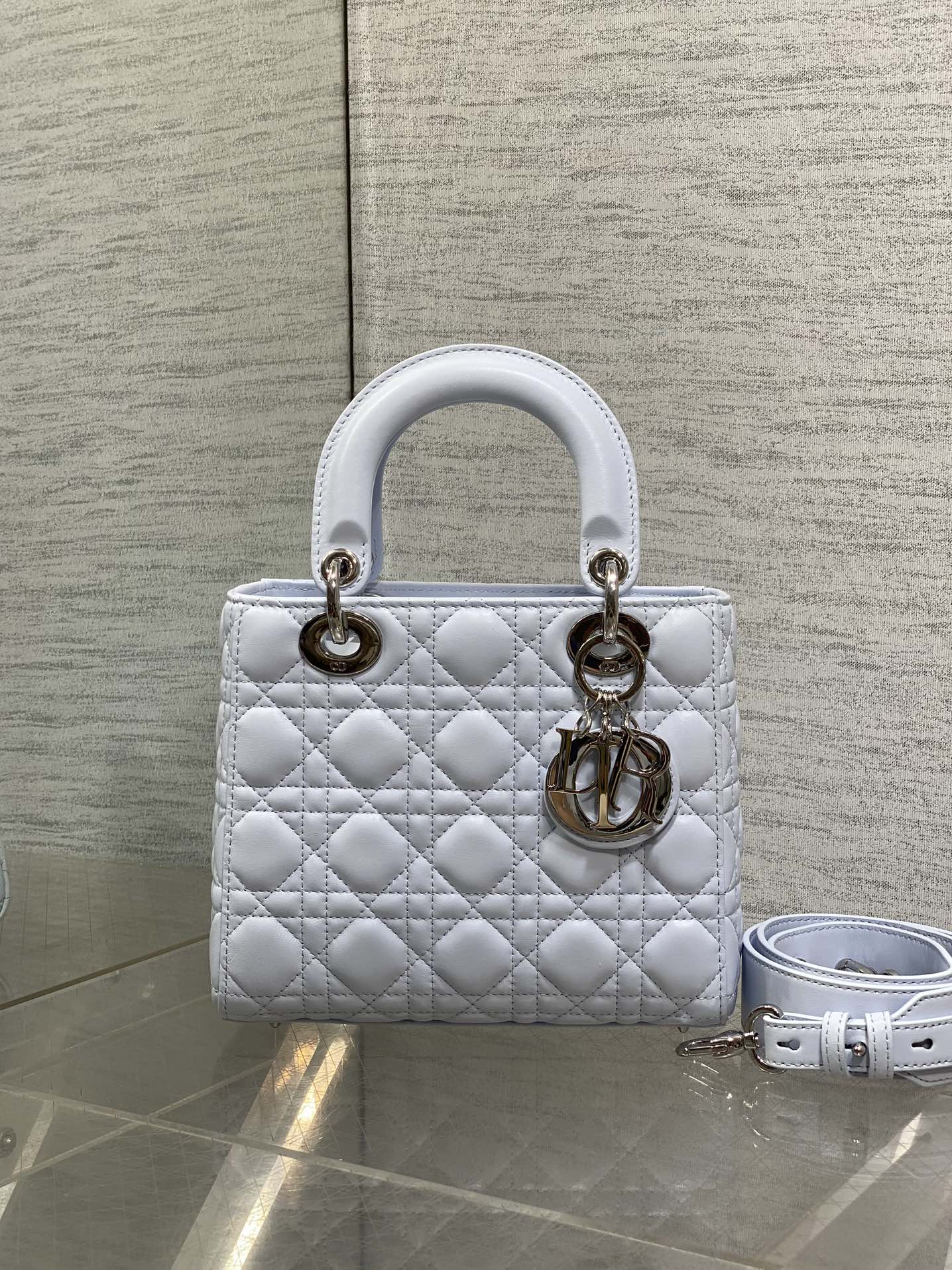 Quilted light blue Dior handbag with gold hardware and detachable shoulder strap