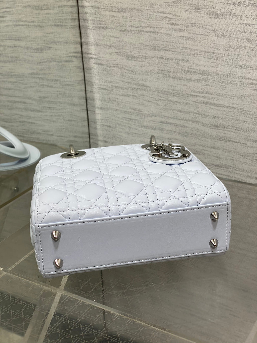 Dior quilted light blue handbag with flap closure, gold feet, and top handles