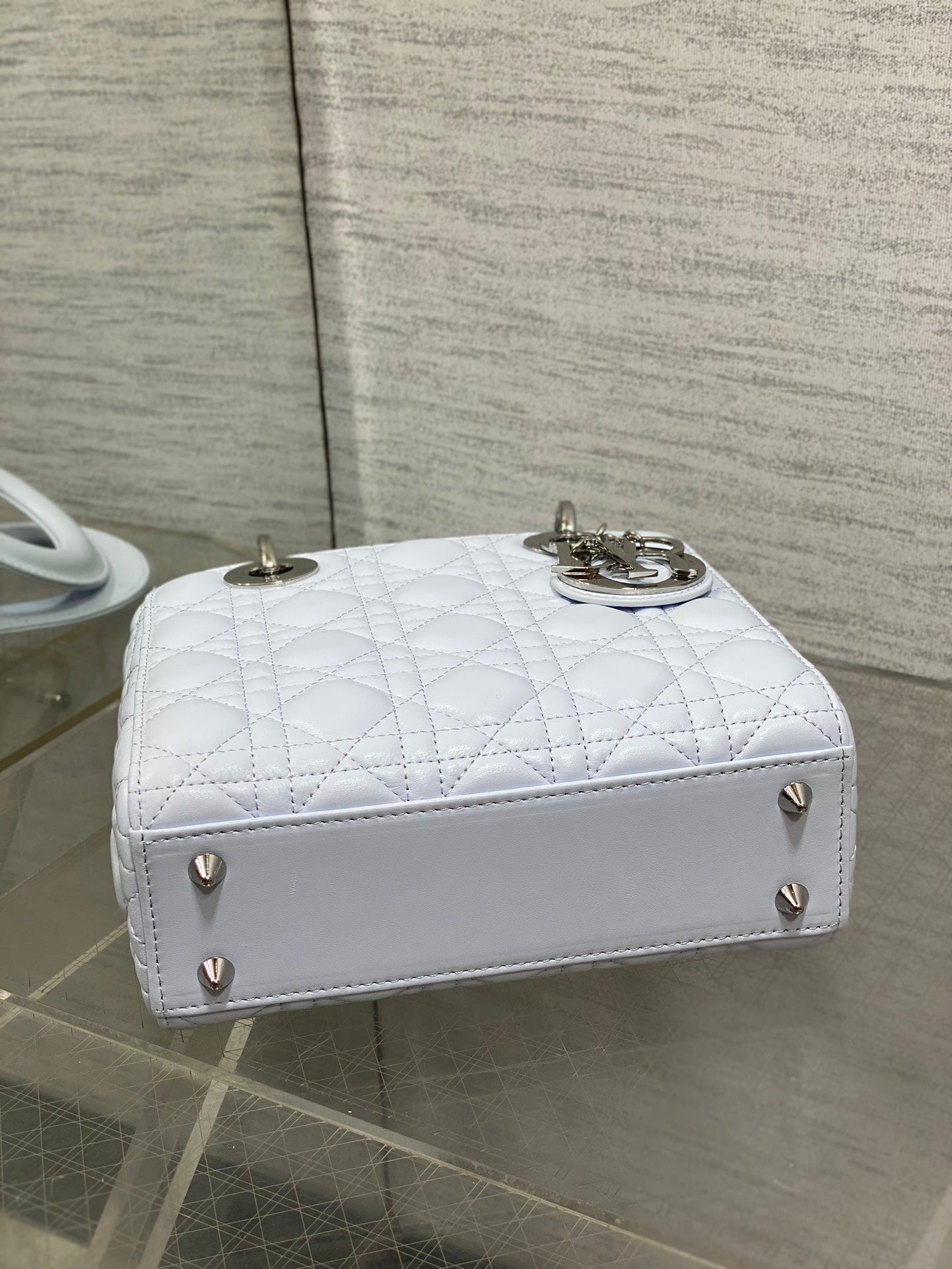 Dior quilted light blue handbag with flap closure, gold feet, and top handles