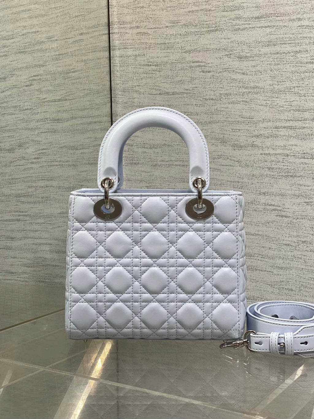 Quilted light blue Dior handbag with top handles and gold hardware, with shoulder strap