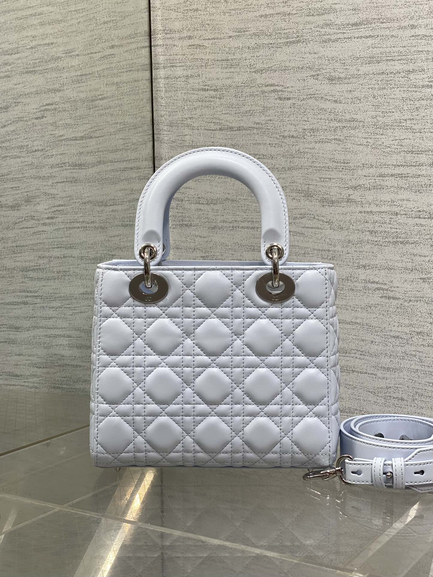 Quilted light blue Dior handbag with top handles and gold hardware, with shoulder strap