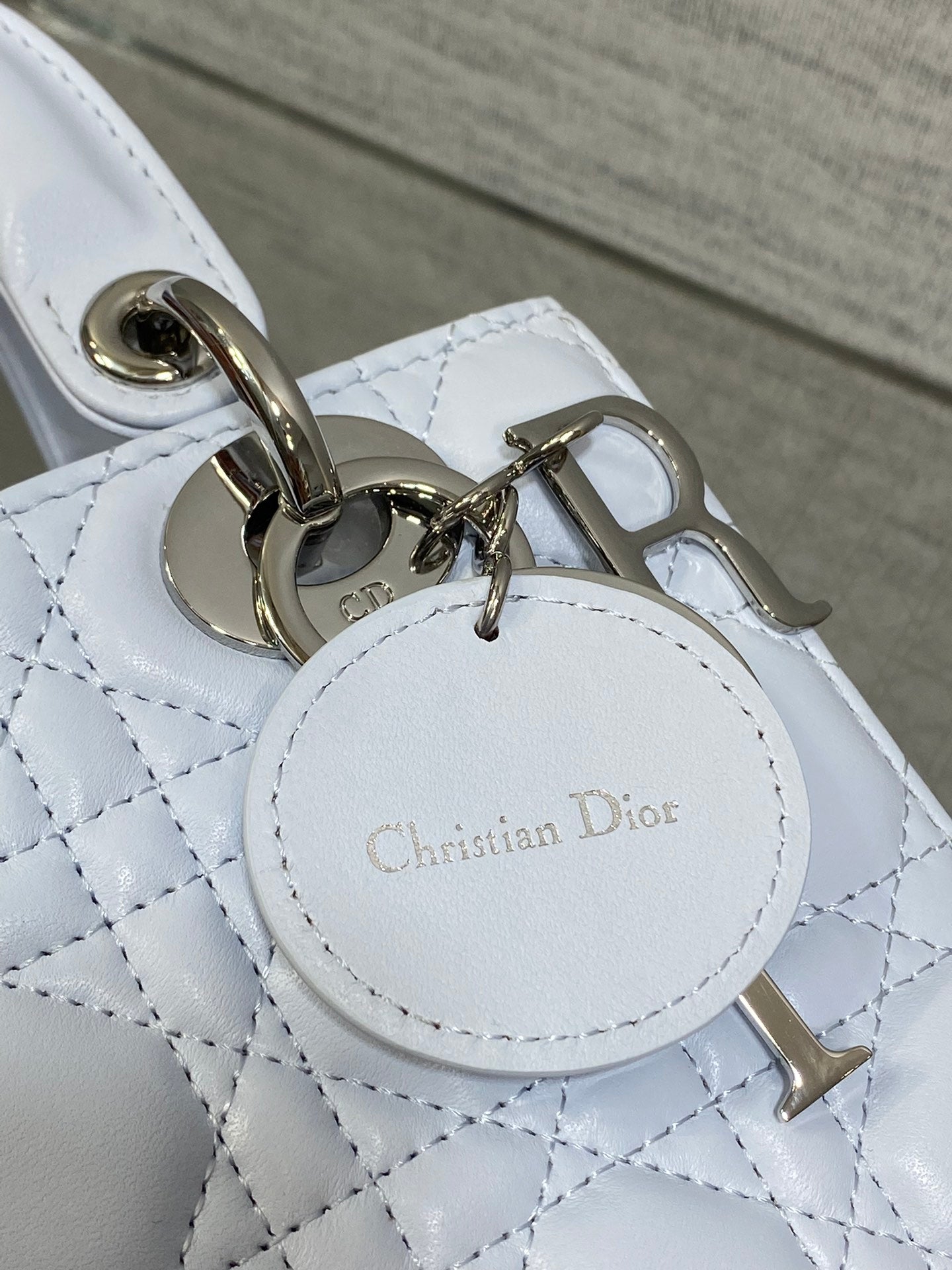 Dior handbag keychain charm and round logo tag on quilted light blue leather