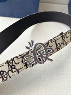 Dior belt close-up: beige logo strap with black inner, gold-toned clasp