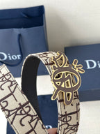 Dior belt close-up: beige logo strap with gold-toned emblem on clasp