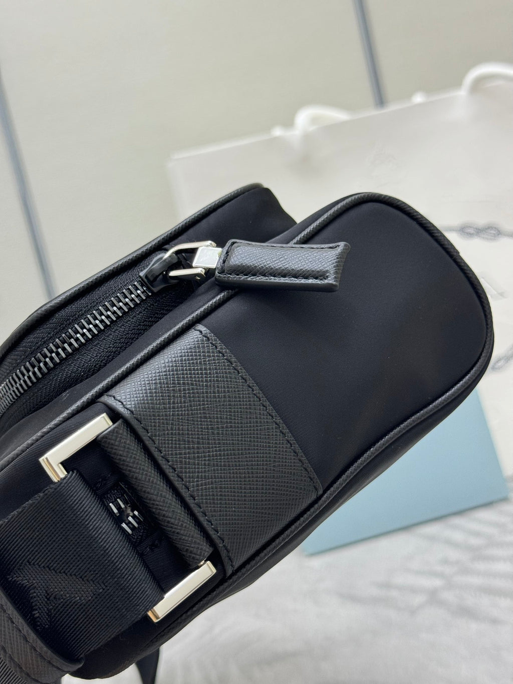 Prada bag, black crossbody with side buckle detail and textured front panel