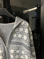 Grey zip-up hoodie angled view with monogram hood lining and sleeve pattern