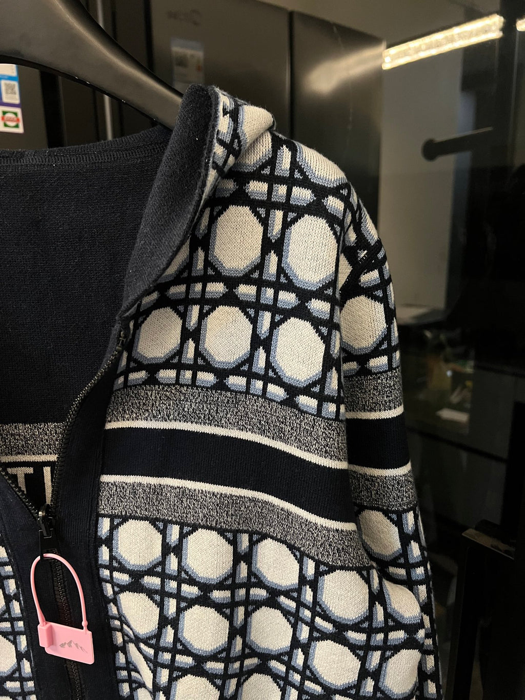 Close-up of hood edge on hooded zip-up jacket with navy-and-white lattice lining