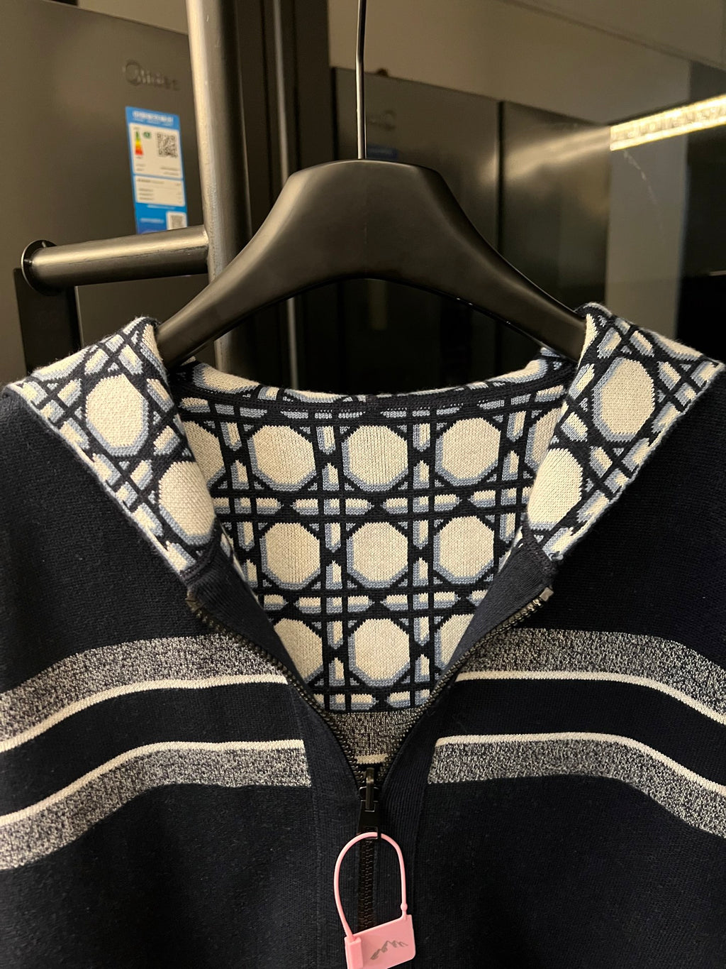 Hooded zip-up jacket with patterned hood lining, navy zip front, and white-gray striped bands