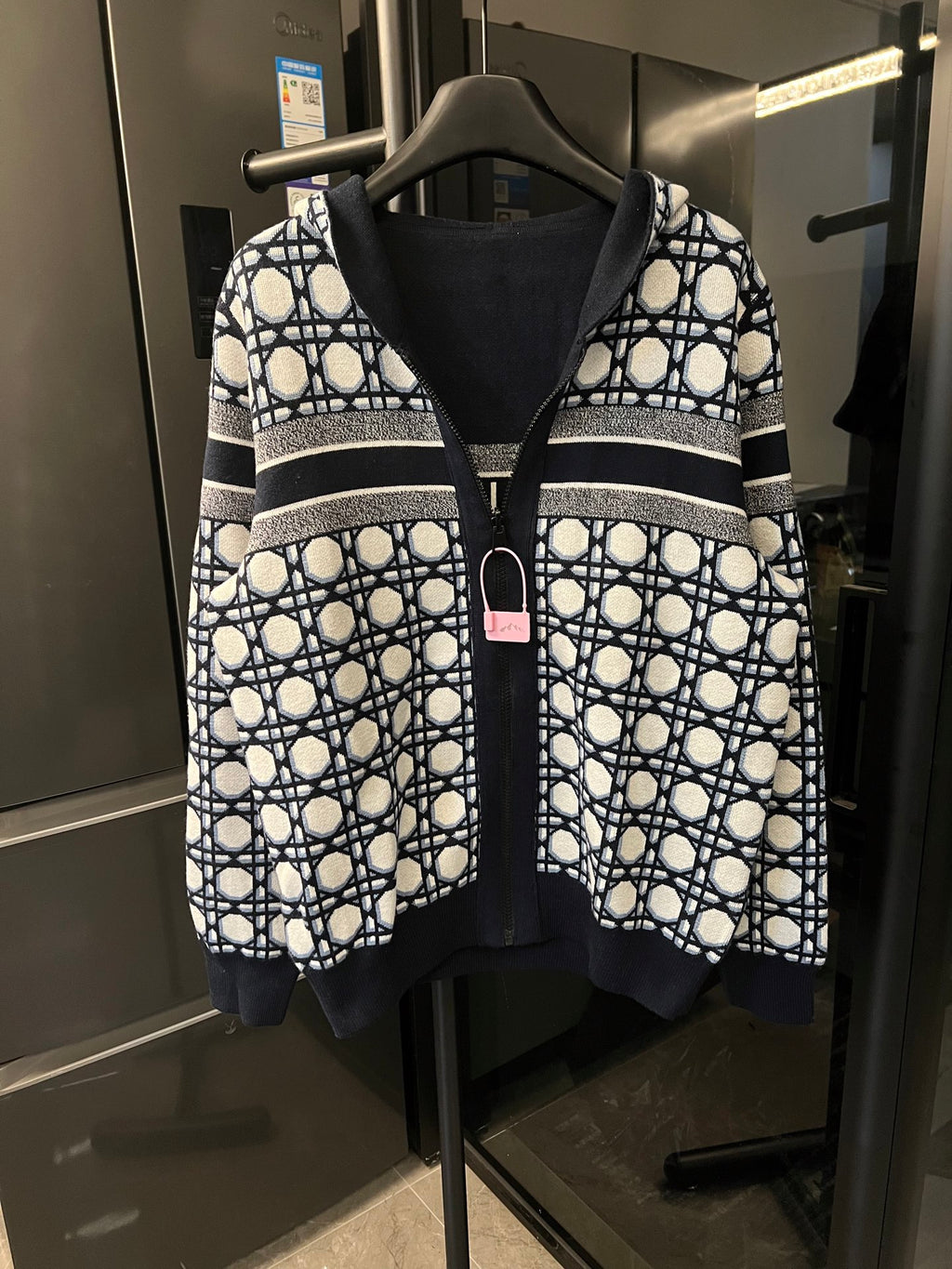 Hooded zip-up jacket with navy and white lattice pattern, ribbed dark cuffs and hem