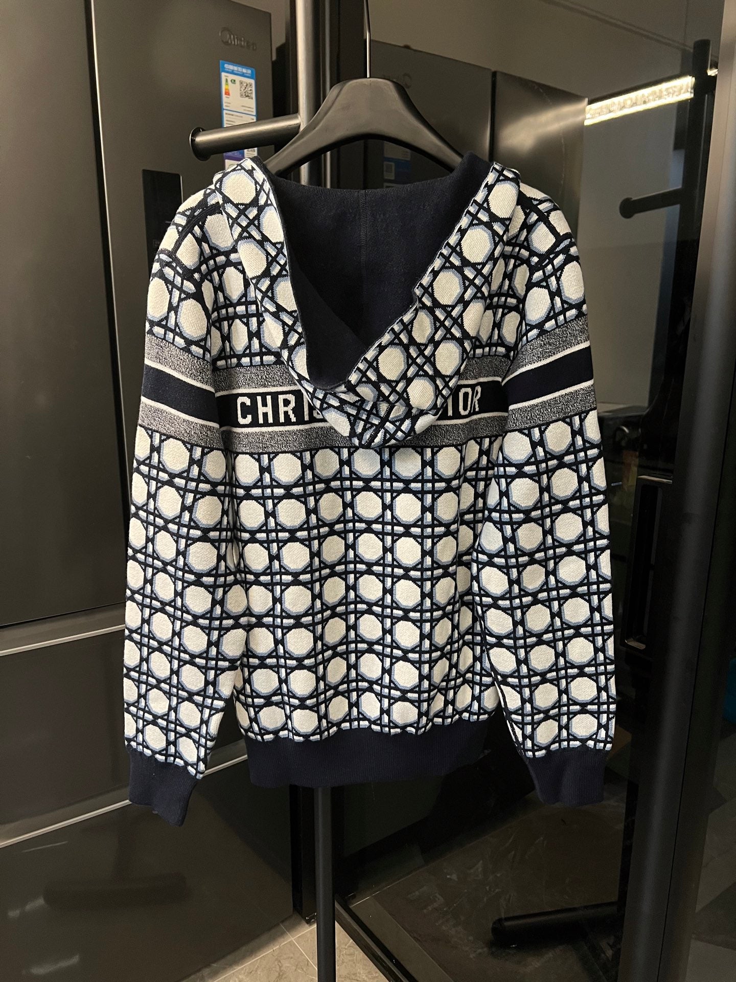 Hooded zip-up jacket with bold lattice print and gray stripe bands at the chest