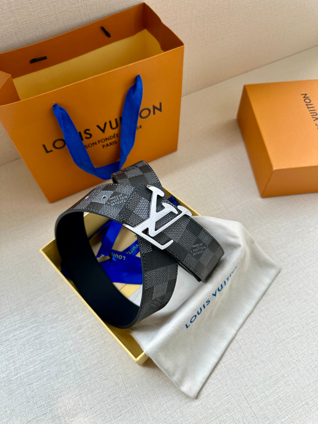 Louis Vuitton Damier check belt laid flat with silver-toned LV buckle