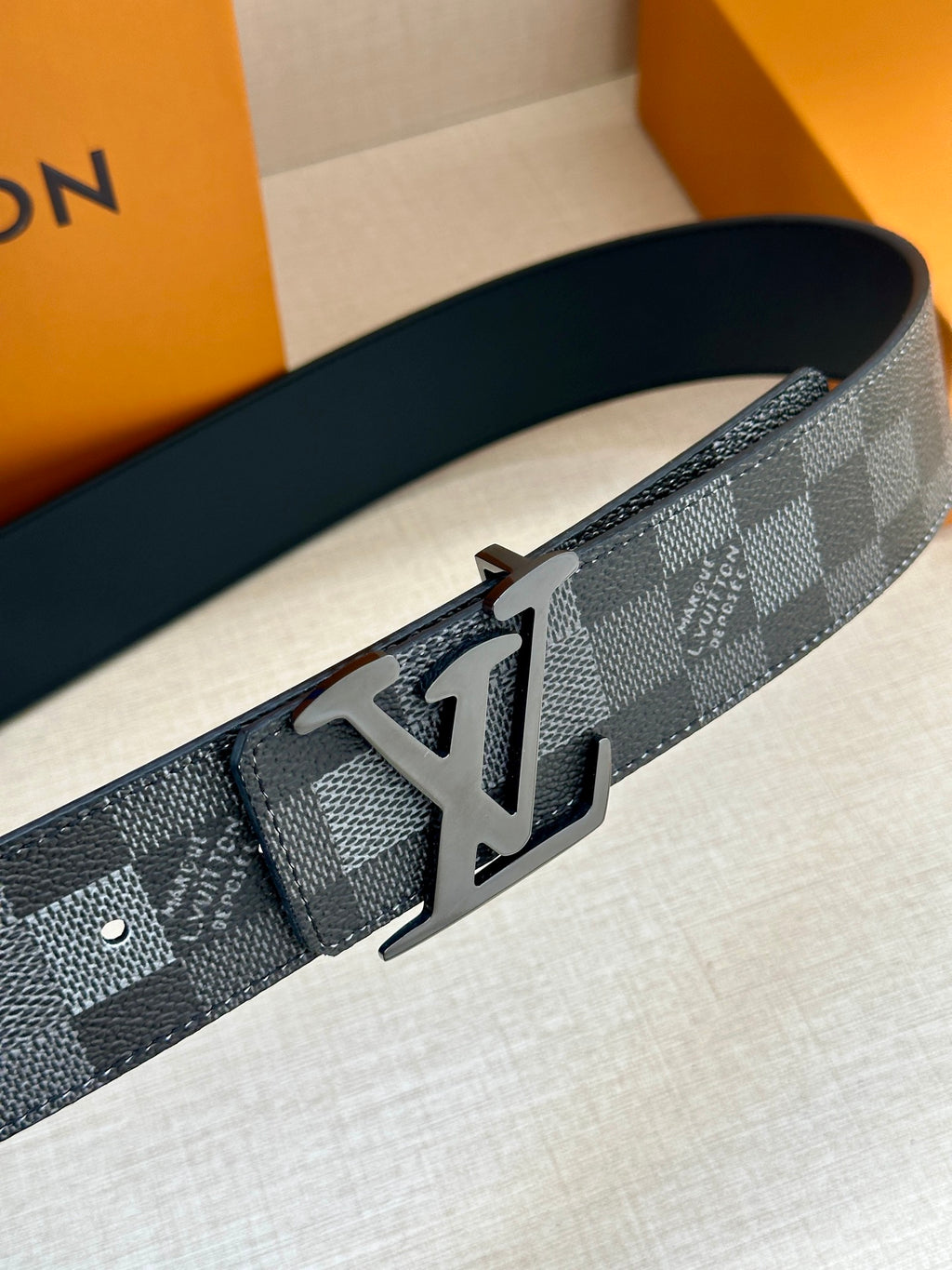 Louis Vuitton Damier check belt with silver-toned LV buckle and adjustment holes