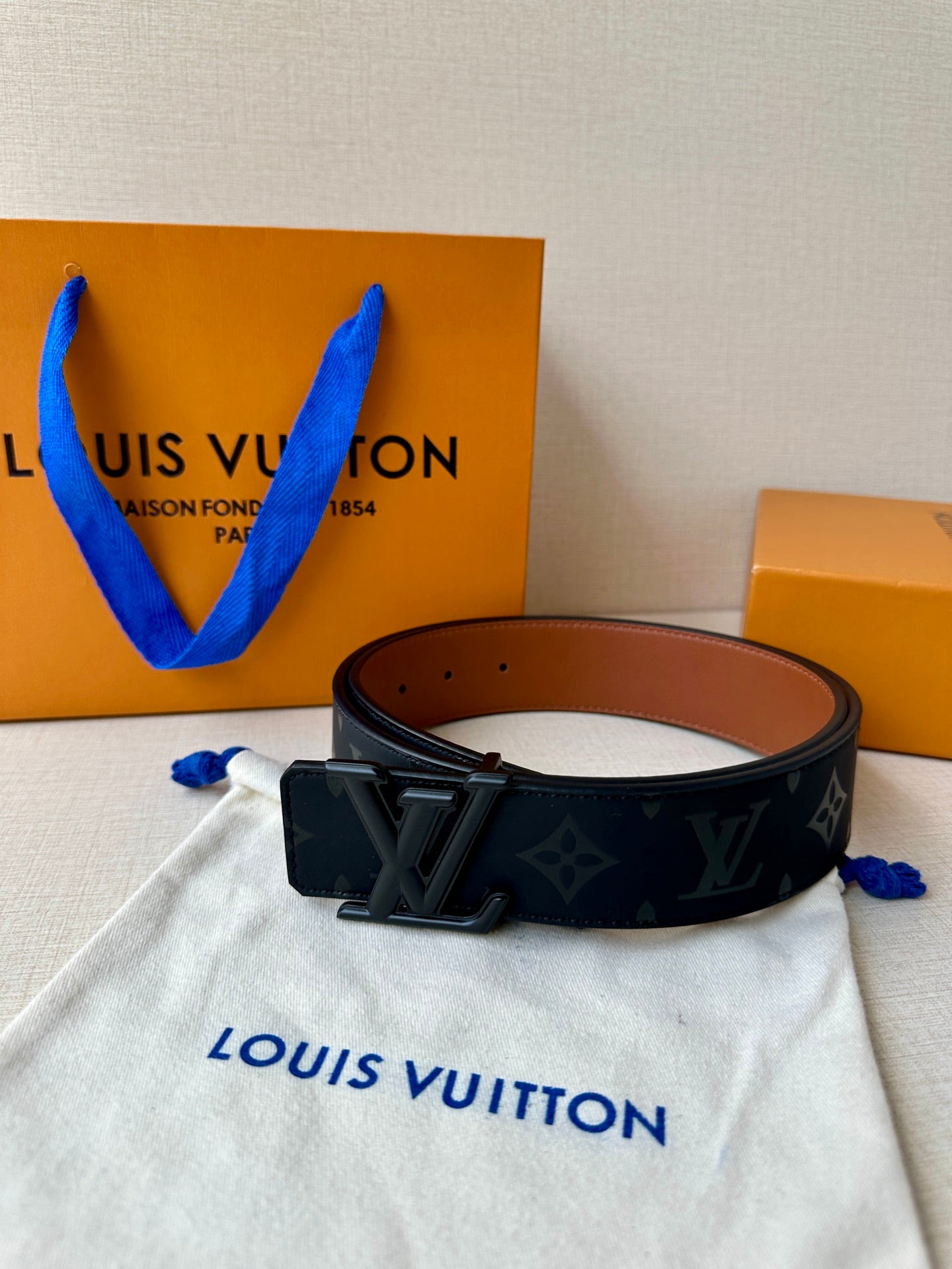 Louis Vuitton belt on dust bag: dark monogram strap, black buckle