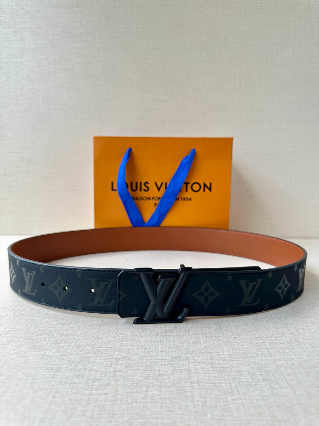 Louis Vuitton belt with dark monogram strap and black metal buckle