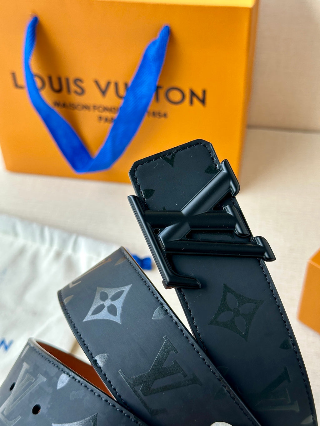 Louis Vuitton belt with dark monogram strap and black rectangular buckle