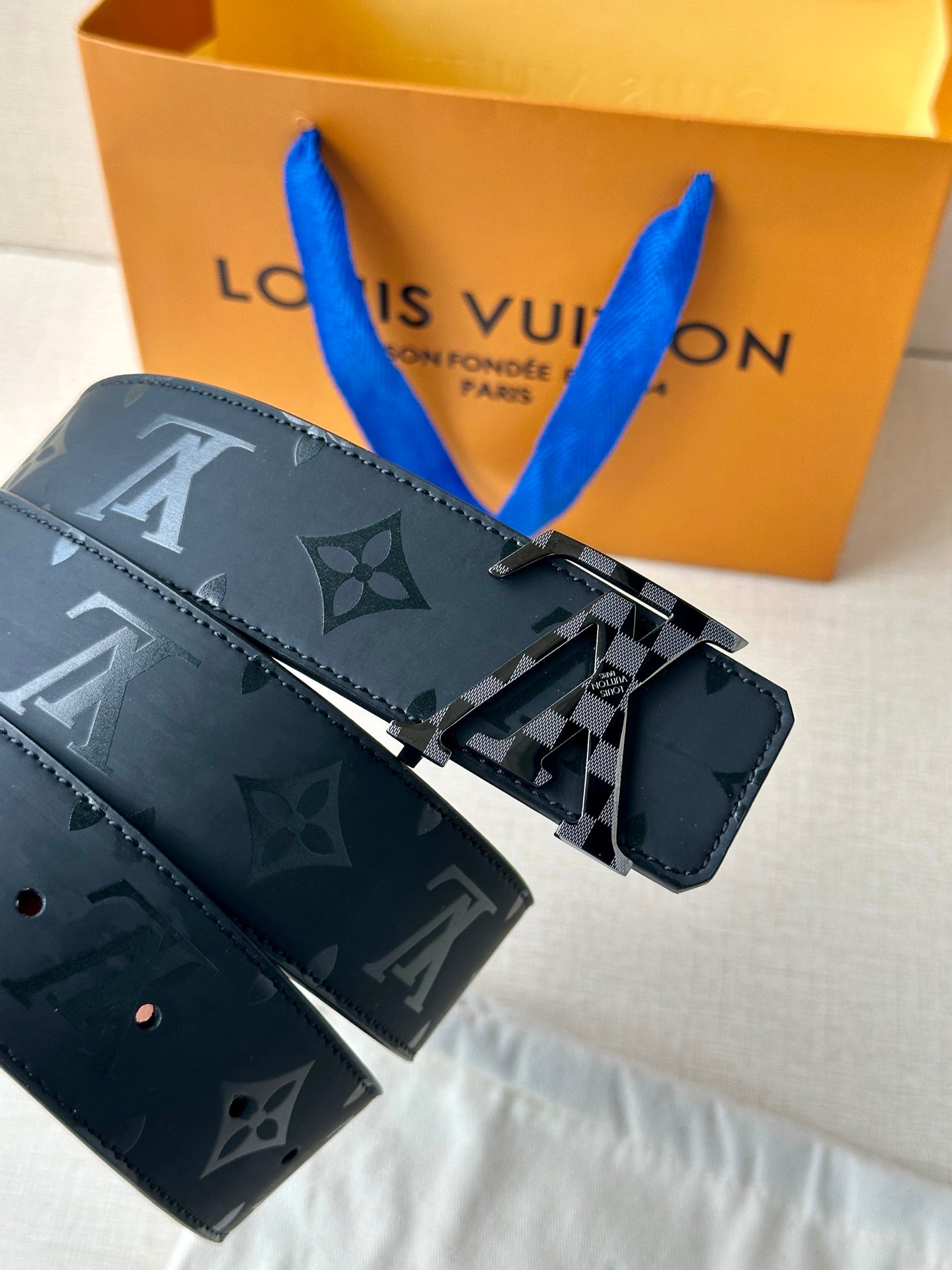 Louis Vuitton belt with dark navy monogram strap and silver "LV" buckle hardware