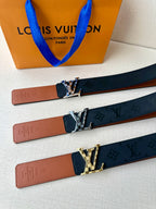 Louis Vuitton belt shown with tan leather strap and dark navy monogram strap with buckles