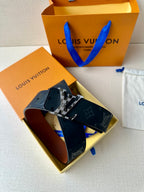 Louis Vuitton belt with dark navy monogram strap and silver buckle, folded display