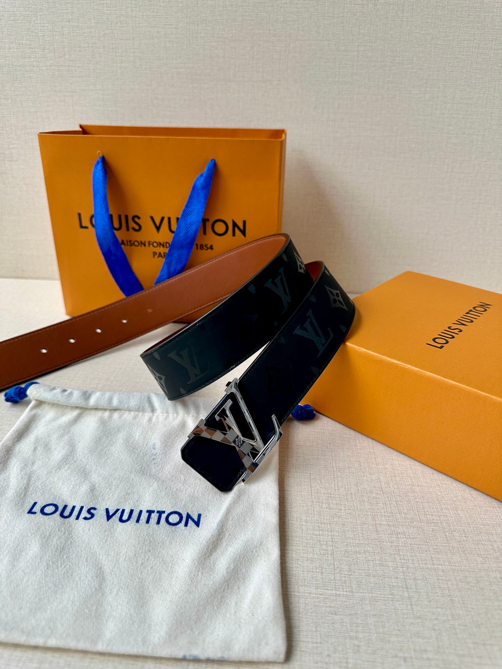 Louis Vuitton belt with dark navy monogram strap and silver buckle centered