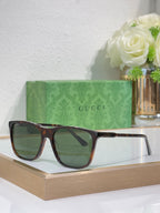 Gucci sunglasses with dark tortoiseshell frame and green-tinted lenses