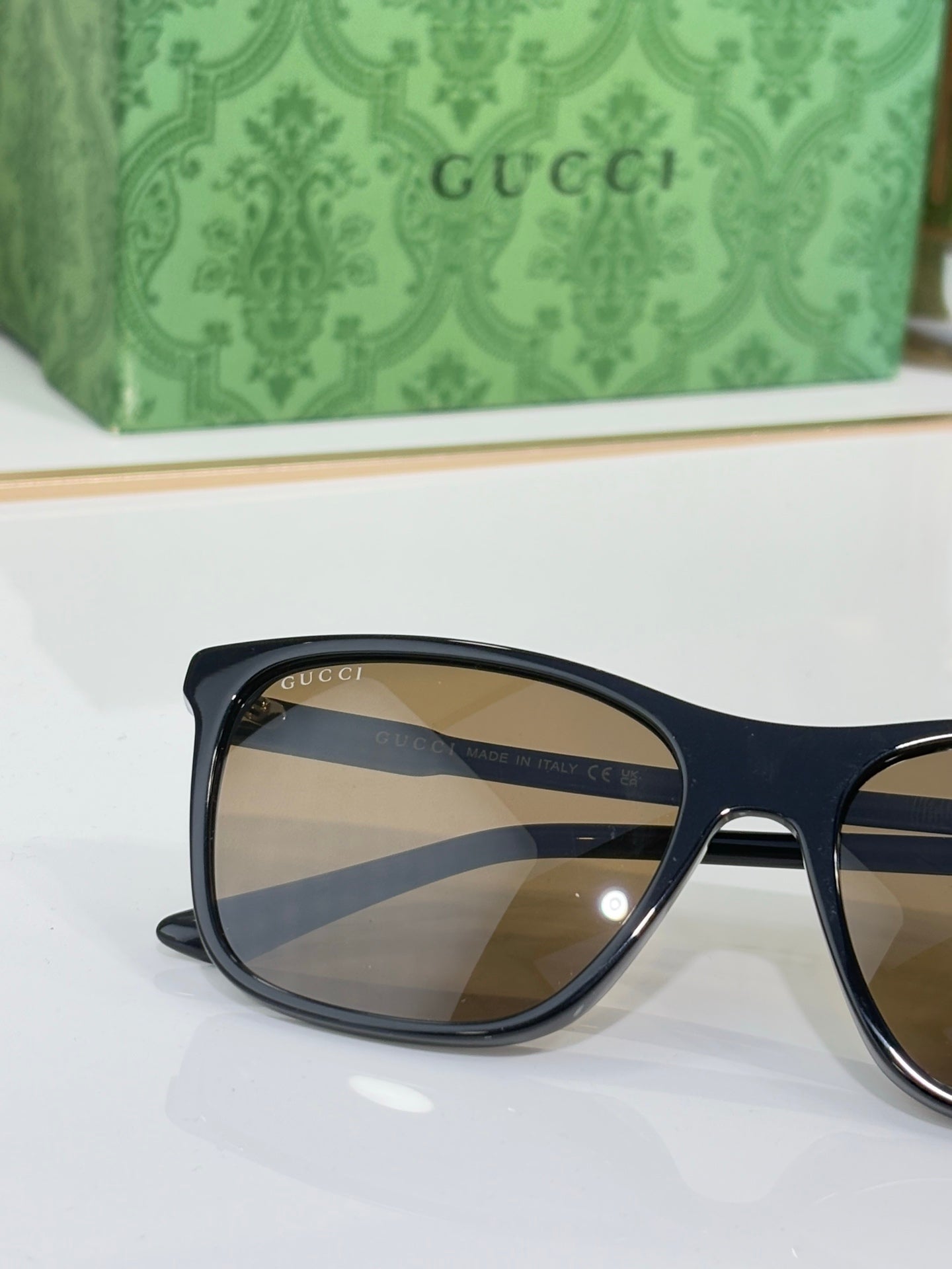 Gucci sunglasses close-up with dark frame and blue-tinted lenses