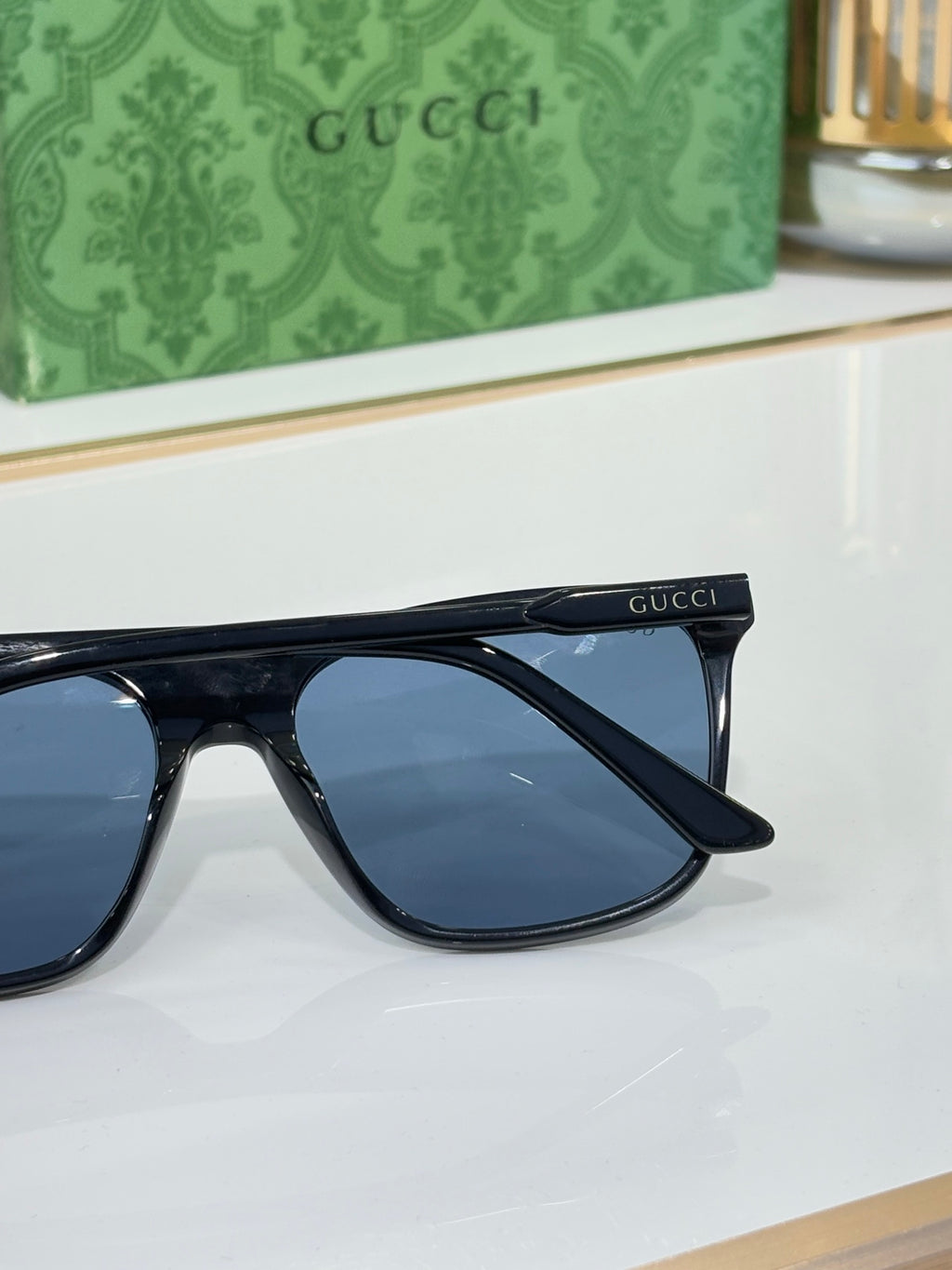 Gucci sunglasses side view with dark frame and blue lens