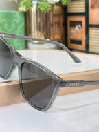 Gucci sunglasses with translucent gray frame and brown lenses