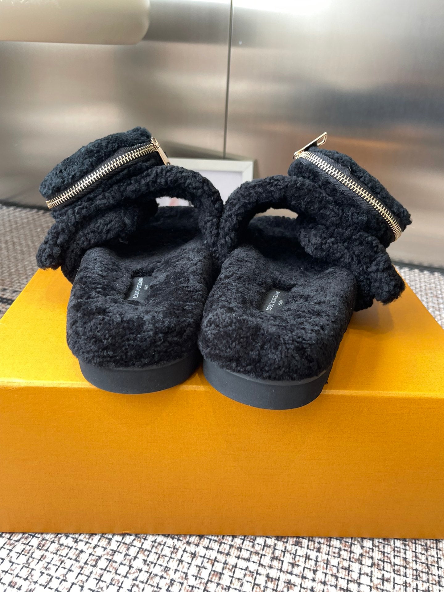 Louis Vuitton unisex black fuzzy slides showing cushioned lining and front zipper